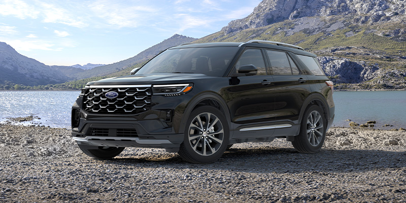 An all-new black 2025 Ford Explorer parked in front of a river and mountains. - Franklin Ford Franklin, MA